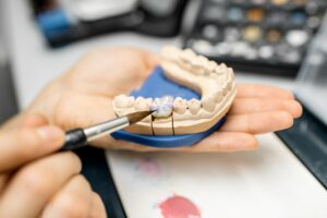 Dental technician coloring dental prosthesis